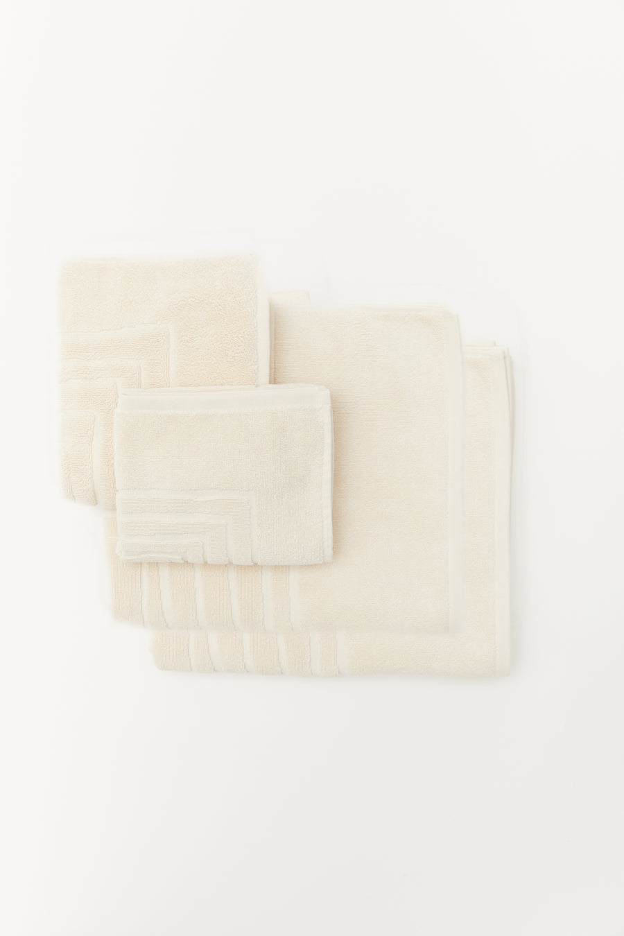 alt="Laze Res organic bath set including bath towel, hand towel, and bath mat in soft neutral tones, neatly folded"