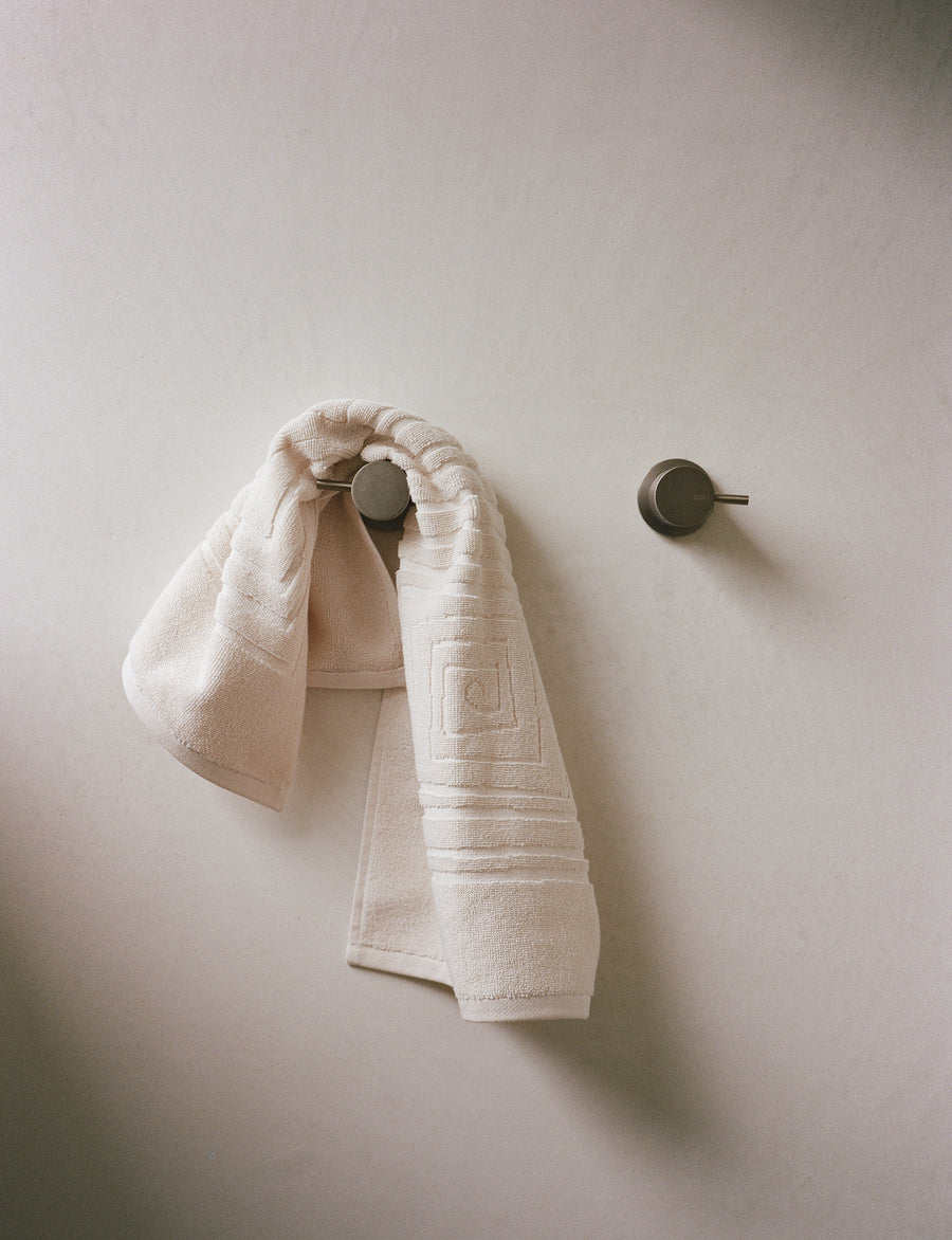 alt="Laze Res organic hand towel hanging in a modern bathroom"