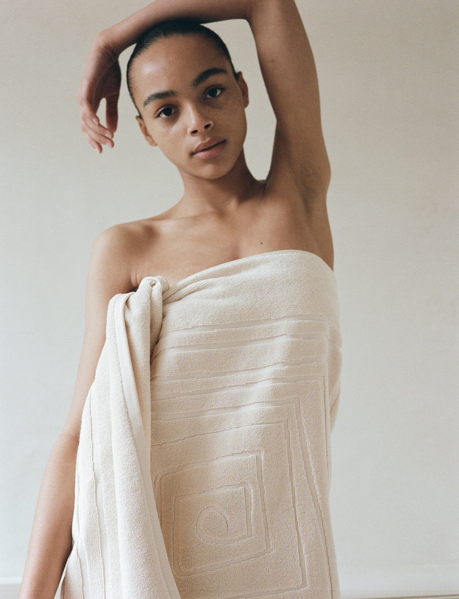 alt="Person wrapping themselves in a Laze Res organic bath towel after a bath"