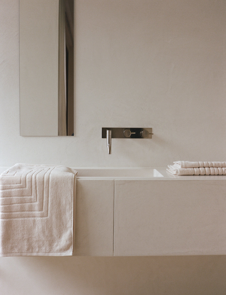 alt="Organic cotton bath set by Laze Res displayed in a minimalist bathroom, evoking calm and daily ritual"