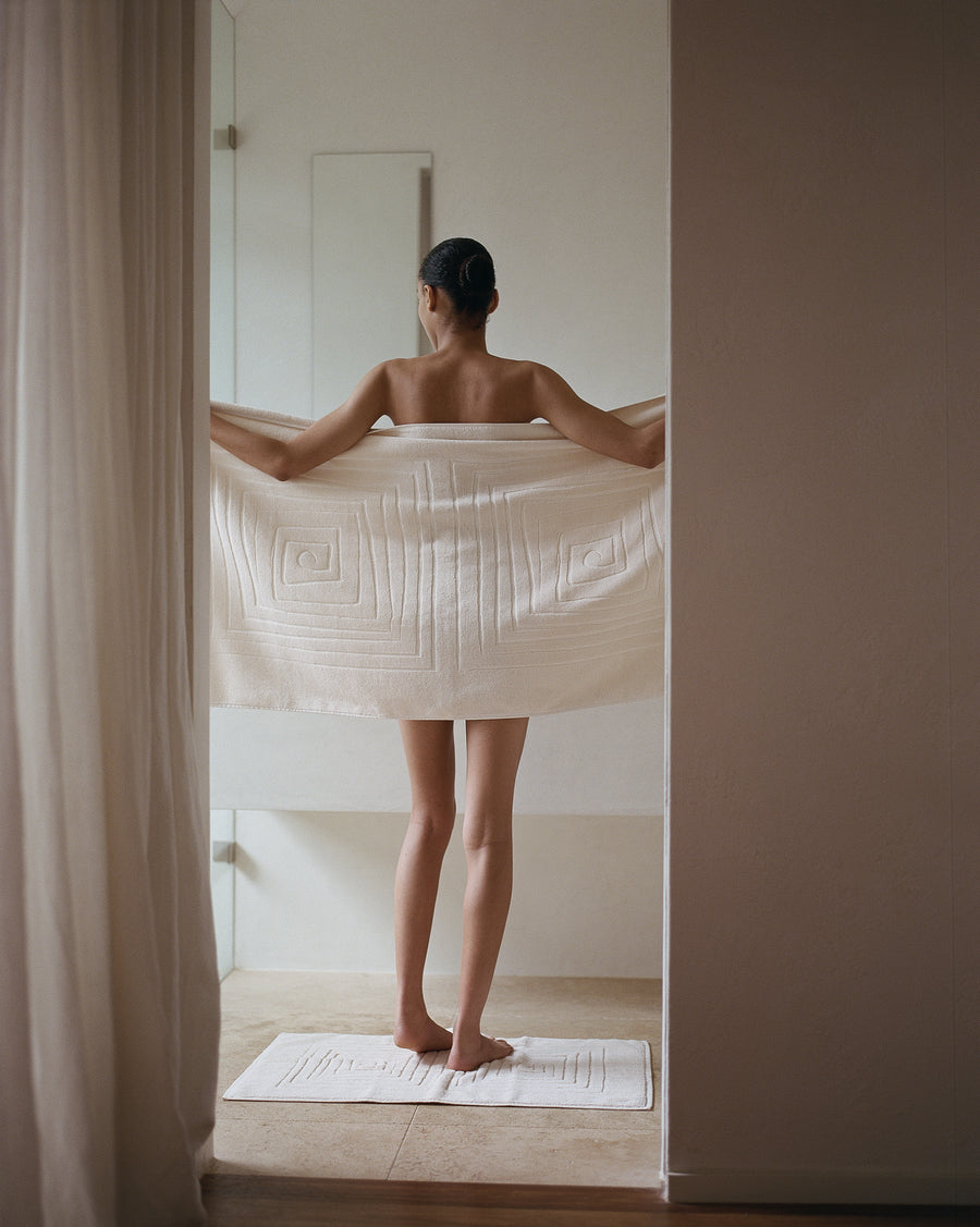 alt="Person wrapping themselves in a Laze Res organic bath towel after a spa bath"