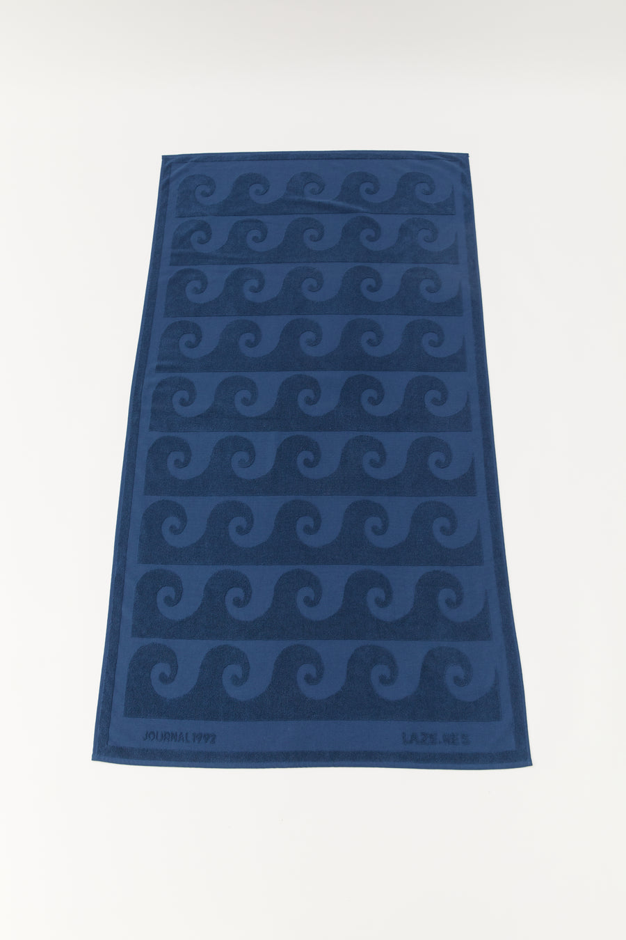 alt=“Detailed view of Laguna Towel’s unique embossed pattern on soft, deep blue Turkish cotton fabric”
