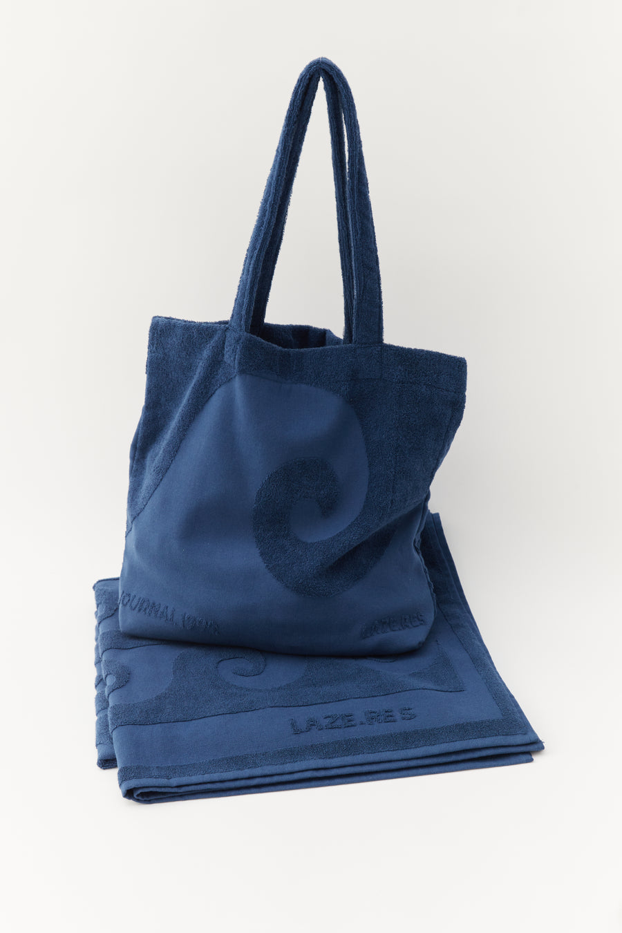 alt=“Detailed view of Laguna Towel’s and tote bag with unique embossed pattern on soft, deep blue Turkish cotton fabric”