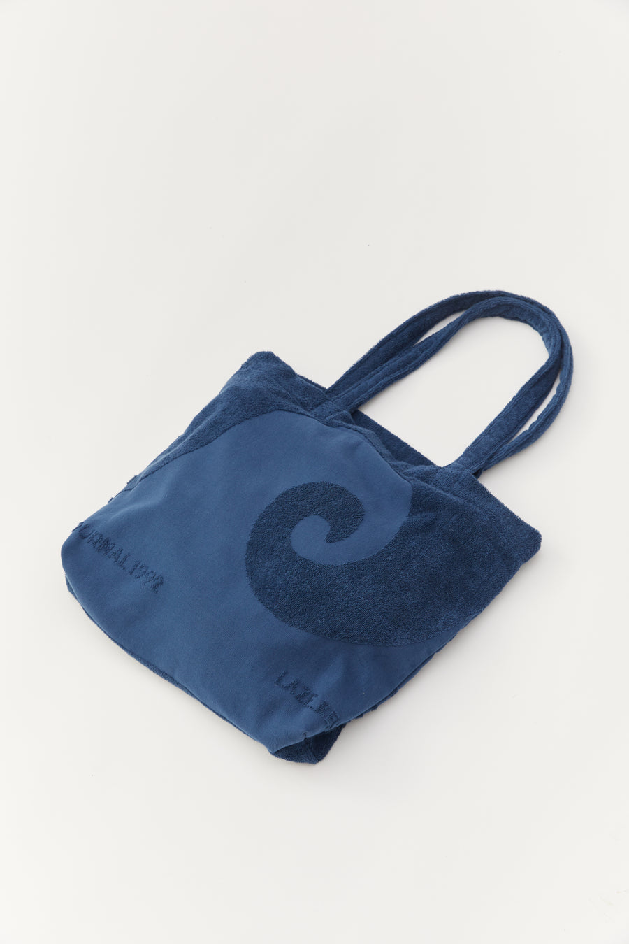 alt="Close-up of Noosa Bag's embossed jacquard weave on soft cotton canvas flat lay"
