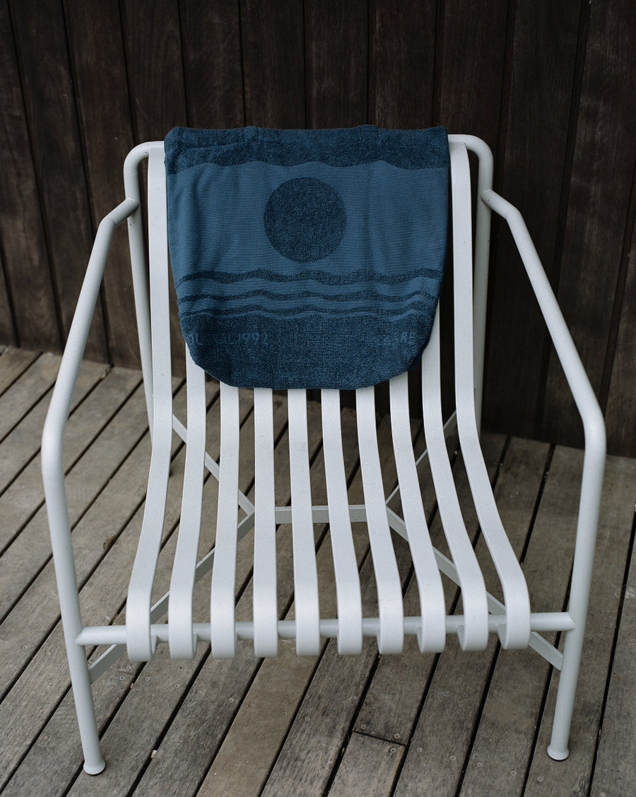 alt="Noosa Bag by Laze Res x Journal 1992 hanging on chair emphasizing minimalist shape and natural texture"